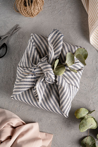 Un furoshiki à bandes bleu et blanc, emballage pour des cadeaux fait en tissu.