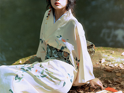 Une jeune femme porte un ancien kimono blanc.
