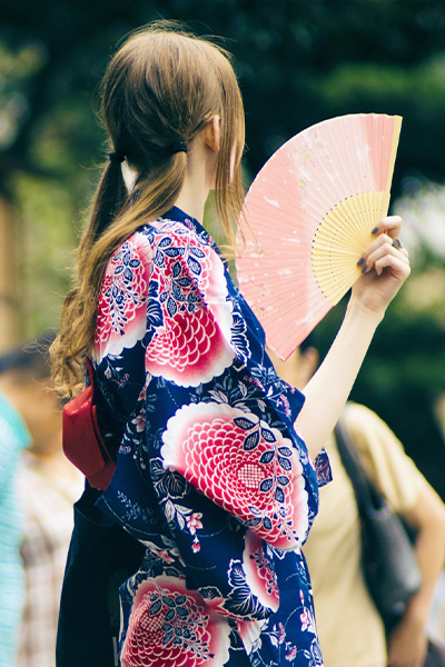 Femme portant un kimono blanc avec des motifs de feuille de bambou teinte en bleu